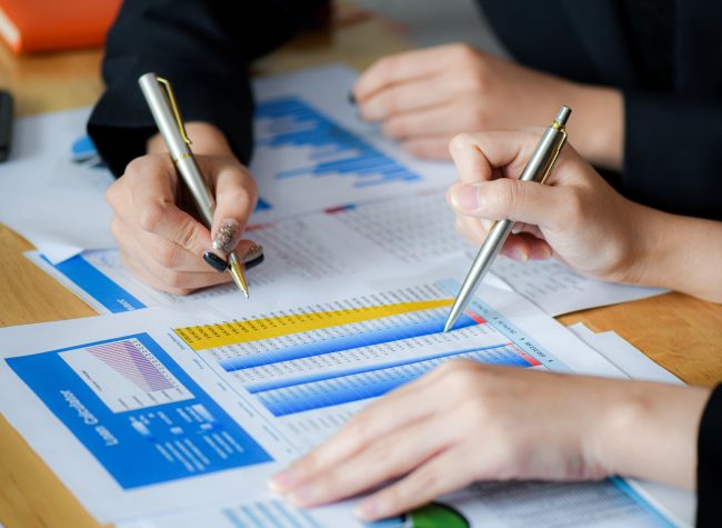 Female office staff are summarizing the number in the office.